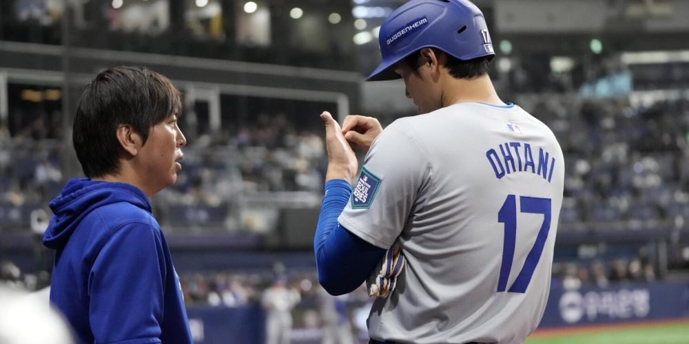 Los Angeles Dodgers designated hitter Shohei Ohtani, right, talks to his interpreter Ippei Mizuhara during the fifth inning of an opening day baseball game against the San Diego Padres at the Gocheok Sky Dome in Seoul, South Korea Wednesday, March 20, 2024, in Seoul, South Korea. (AP Photo/Lee Jin-man)