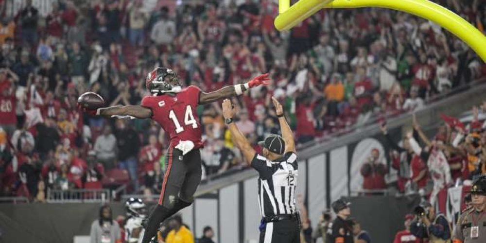 El wide receiver Chris Godwin (14), de los Buccaneers de Tampa bay, celebra después de una recepción de touchdown, mientras el árbitro Greg Steed (12) marca la anotación, durante la segunda mitad del juego de comodines de la NFL en contra de los Eagles de Filadelfia, el lunes 15 de enero de 2024, en Tampa, Florida. (AP Foto/Phelan M. Ebenhack)
