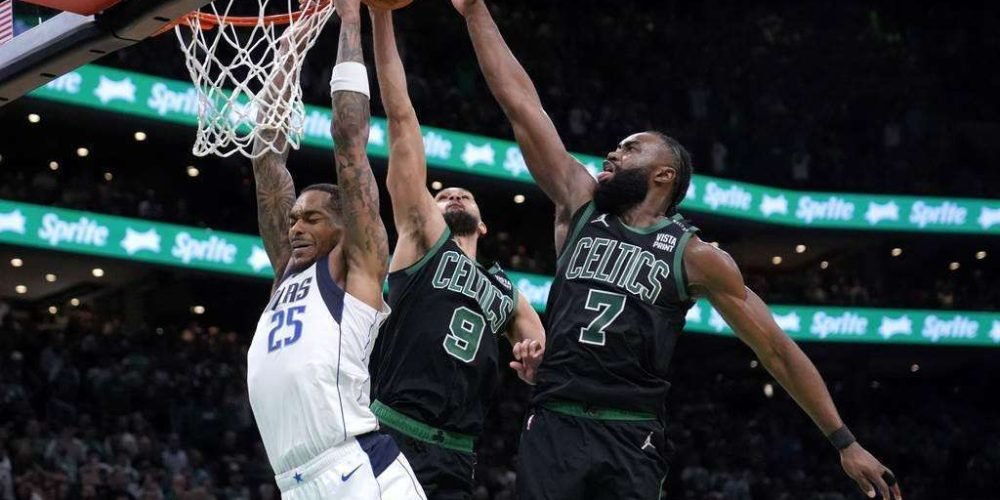 A P.J. Washington (25), de los Mavericks de Dallas, le bloquean un intento de retacada Derrick White (9) y Jaylen Brown (7), de los Celtics de Boston, durante la segunda mitad del Juego 2 de las Finales de la NBA, el domingo 9 de junio de 2024, en Boston. (AP Foto/Steven Senne)