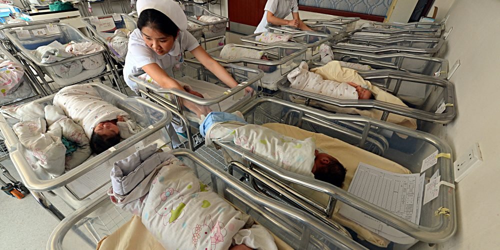 --FILE--Chinese nurses take care of newborn babies at a maternity hospital in Lanzhou city, northwest China's Gansu province, 16 February 2016. China's population is expected to reach about 1.42 billion by 2020, according to the National Health and Family Planning Commission. As of the end of 2015, China had a population of about 1.37 billion. The annual natural population growth rate will be around six per thousand while China's gender ratio at birth is expected to be reduced to 112 boys for every 100 girls by 2020. (Photo by Pei qiang / Imaginechina / Imaginechina via AFP)