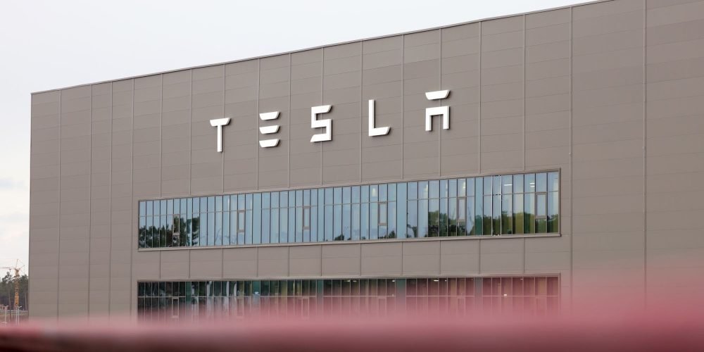 The logo of Tesla Inc. at the automaker's Gigafactory in Gruenheide, Germany, on Saturday, Jan. 21, 2023. Tesla CEO Elon Musk played down how much impact his tweets have on the company's stock price as he defended himself at a trial in San Francisco federal court on Friday over his 2018 tweet about taking the electric car-maker private. Photographer: Liesa Johannssen/Bloomberg